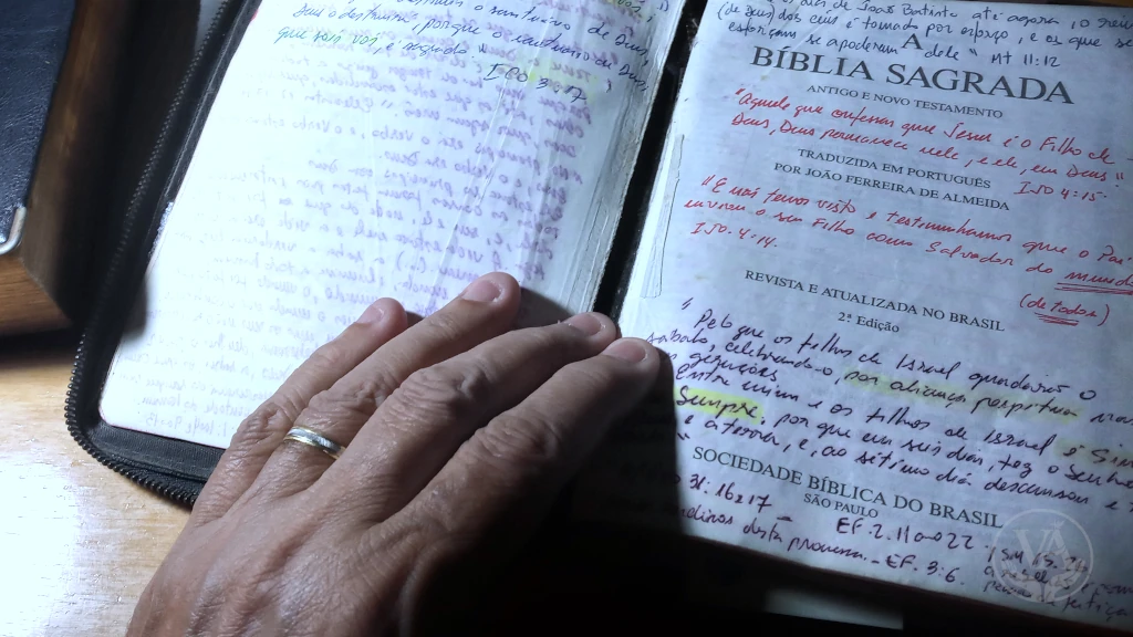Uma Bíblia aberta nas primeiras páginas com muitas anotações de versículos e passagens que ajudam a memorização das Escrituras.
